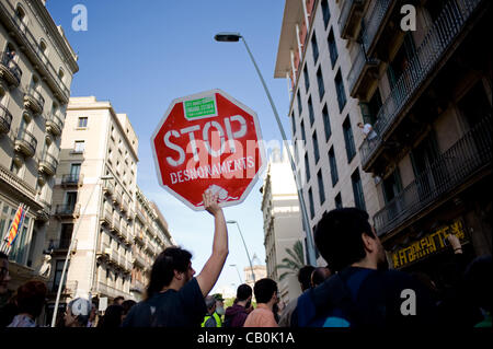 15 May, 2012-Barcelona, Spain. An 'Indignado holding a placard that reads -stop evictions- in front of a bank. Several groups of 'Indignados' perform actions against banks in Barcelona due to evictions because of crisis Stock Photo