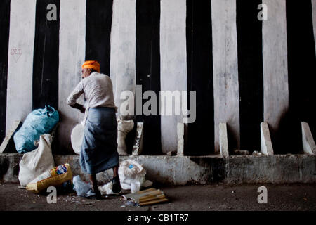 May 16, 2012 - New Delhi, India - An addict collects trash under a bridge in the Yamuna Bazaar that he will later sell for drug money. His daily routine consists of collecting trash, selling it, buying drugs, shooting up and repeating that cycle. Approximately 1,200 drug addicts live on the streets  Stock Photo