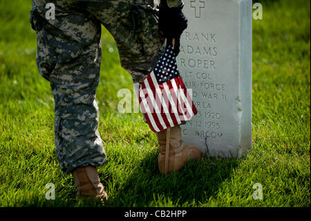 May 24, 2012 - Arlington, Virginia, U.S. - Members of the 3rd U.S. Infantry, known as The Old Guard, place American flags before gravestones and niches of service members buried at Arlington National Cemetery in advance of the Memorial Day weekend. The tradition, known as ''flags in,'' is conducted  Stock Photo