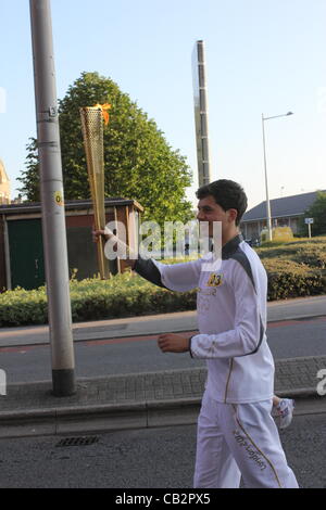 CARDIFF, UK, 26th May 2012. Zak Lee-Green, 21, carries the Olympic flame through Cardiff Bay during the London 2012 Olympic torch relay. Stock Photo