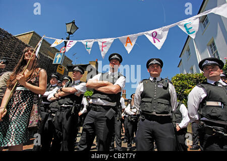 Putney, London, UK. Saturday 26th May 2012. Police out in force in a line to stop protestors of UK uncut storming the home of Nick Clegg in Putney, London to hold an alternative street party to protest about UK cuts and austerity measures. Stock Photo