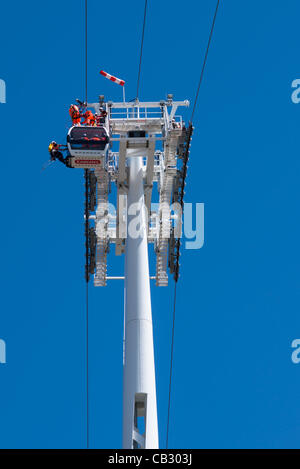 Workmen hang precariously 50 metres up as they put final touches to Emirate's Air line. Greenwich Penisula, London. Stock Photo