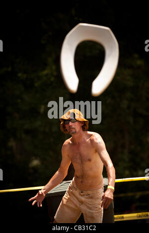 A competitor throws a toilet seat during the Toilet Seat Horse Shoe contest at the Summer Redneck Games on May 26, 2012 in East Dublin, Georgia. Stock Photo