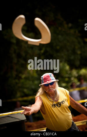 A competitor throws a toilet seat during the Toilet Seat Horse Shoe contest at the Summer Redneck Games on May 26, 2012 in East Dublin, Georgia. Stock Photo