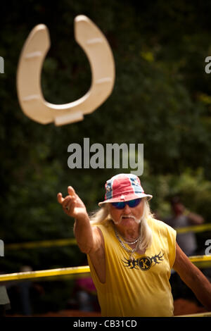 A competitor throws a toilet seat during the Toilet Seat Horse Shoe contest at the Summer Redneck Games on May 26, 2012 in East Dublin, Georgia. Stock Photo