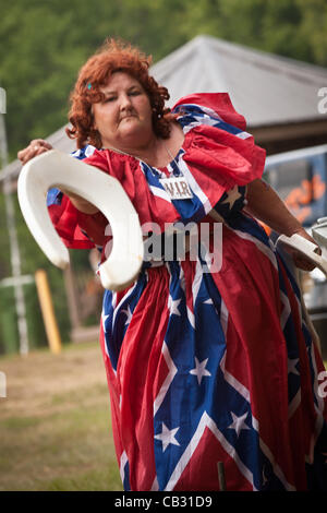 A competitor throws a toilet seat during the Toilet Seat Horse Shoe contest at the Summer Redneck Games on May 26, 2012 in East Dublin, Georgia. Stock Photo