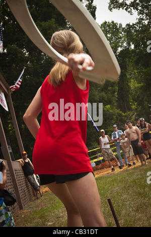 A competitor throws a toilet seat during the Toilet Seat Horse Shoe contest at the Summer Redneck Games on May 26, 2012 in East Dublin, Georgia. Stock Photo