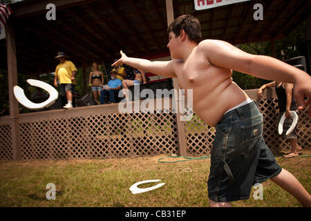 A young competitor throws a toilet seat during the Toilet Seat Horse Shoe contest at the Summer Redneck Games on May 26, 2012 in East Dublin, Georgia. Stock Photo