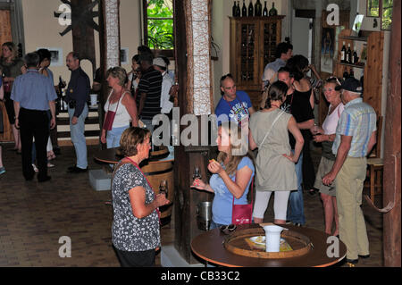 Customers sample wines in a Swiss wine cellar in the canton of Vaud during a ‘caves ouvertes’ (open cellars) event. It is not widely-known that Switzerland produces wine. Most of the production is drunk locally and little exported. Every year the Vaudois wine producers celebrate their harvest Stock Photo