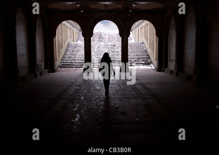 A lone girl walks through the Bethesda Terrace arcade in the snow in the New York winter Stock Photo