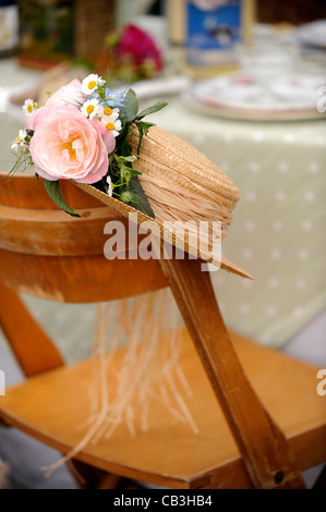 Straw hat on the back of a wooden chair. Stock Photo