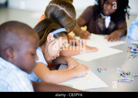 children drawing with crayons around a table Stock Photo - Alamy