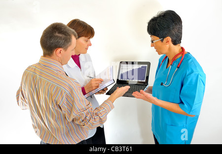 doctor using computer and reviewing medical reports Stock Photo