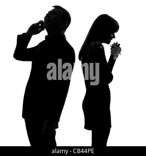 one caucasian couple standing back to back man on the phone  and woman crying in studio silhouette isolated on white background Stock Photo