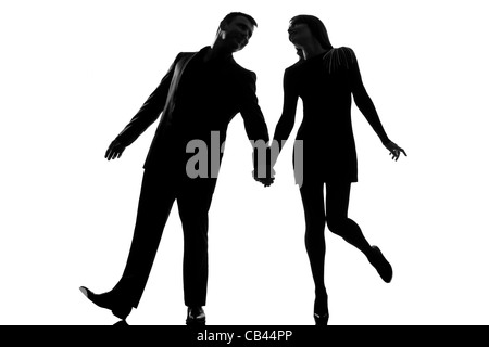 one lovers caucasian couple man and woman walking holding hands  in studio silhouette isolated on white background Stock Photo