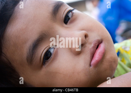 A hungry street child boy living in poverty is in need of food on the streets of Phnom Penh, Cambodia. Stock Photo