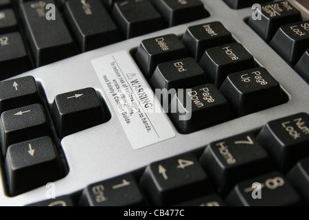 close up of carpal tunnel warning on gray and black computer keyboard Stock Photo