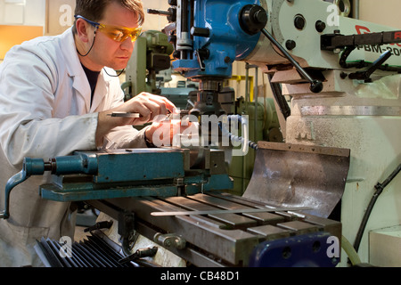 Engineering technician, Engineer working a milling machine with Engineering plans Stock Photo