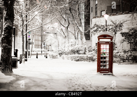 London Snow: Pretty snow scene of traditional red telephone box, The Embankment, City of Westminster, London, UK Stock Photo