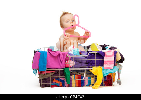 Baby in basket with clothes with hanger, isolated on white Stock Photo