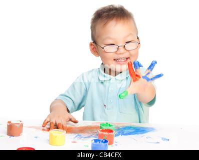 Chinese boy painting with hands with different color paint on his palms Stock Photo