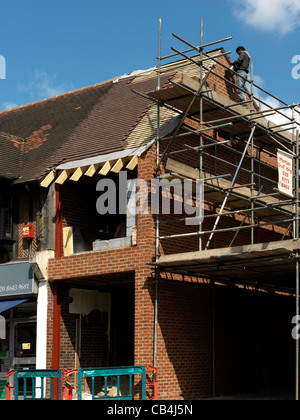 Man On Scaffolding Working On Construction Expansion Of A Shop With A Flat Above England Stock Photo