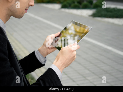 Businessman working outdoors with tablet pc at the park. Stock Photo