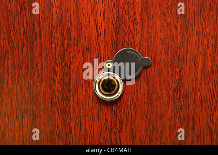 Peephole on wooden door - judas hole spyhole Stock Photo
