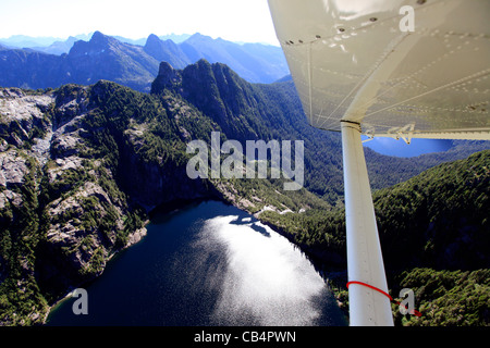 Flying over a mountain lake in Vancouver Island with a floatplane Stock Photo