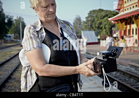 Female photographer with an unusual pellicle mirrored stereo 3D camera rig utilizing two compact cameras. Stock Photo