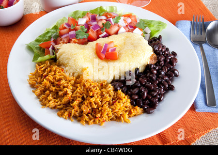 Burrito plate with a side of black beans rice and a fresh salad. Stock Photo