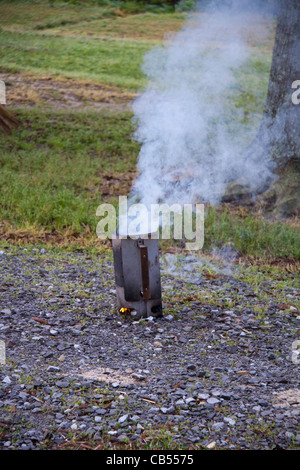 Chimney starter with burning coals for Dutch Oven outdoor cookout. Used to start coals burning for use in Dutch Ovens. Stock Photo