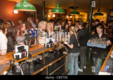 Busy bar filled with young males and females. Stock Photo