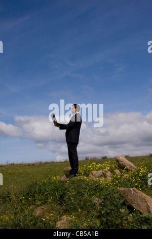 businessman working with a laptop in a field Stock Photo
