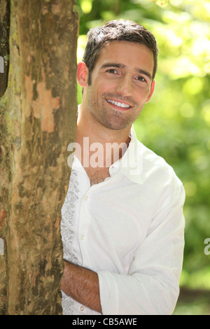 portrait of a man next to a tree Stock Photo