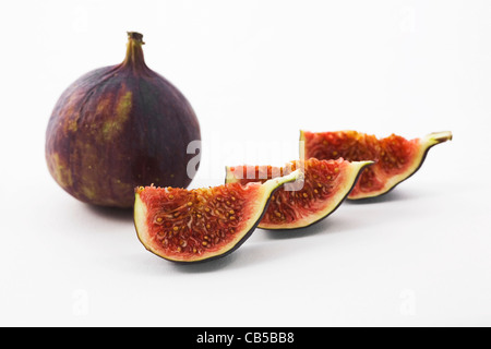 Ficus carica. A single black Bursa fig and three segments on a white background. Stock Photo