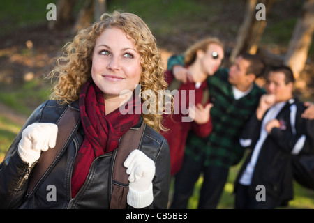 Pretty Young Teen Girl with Three Boys Behind Admiring Her. Stock Photo