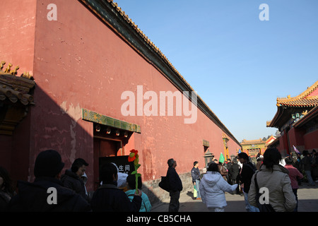 iconic red wall of The Forbidden City with tour groups in shadows beneath, World Heritage Site, Beijing, China, Asia. Stock Photo