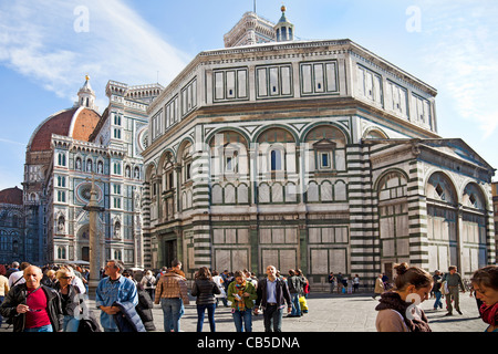 Tourists and locals outside the Battistero di San Giovanni, Baptistry of St John, in central Florence, Italy. Duomo background. Stock Photo