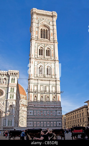 Tourists and locals outside Giotto's Campanile beside the Duomo in Florence, Tuscany, Italy, with horse and carriages Stock Photo