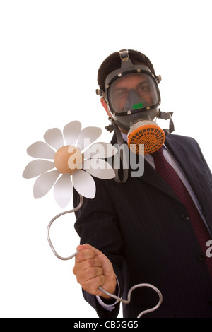 a businessman with a gas mask holding a flower from the future (selective focus) Stock Photo