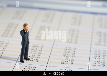 miniature businessman analysing financial data (selective and soft focus) Stock Photo
