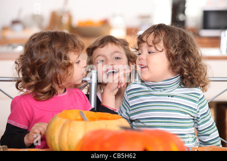 three kids in a kitchen at Halloween time Stock Photo