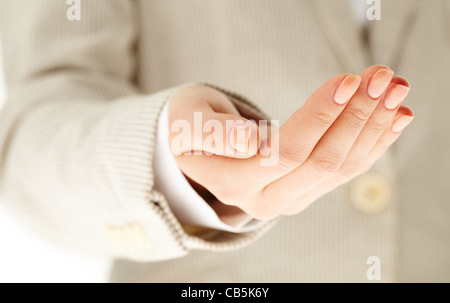 Image of human hand keeping palm up on background of female Stock Photo