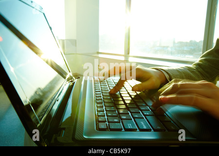 Image of black laptop keyboard with female hands touching it Stock Photo