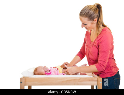 Mother changing child's diaper on nursery table isolated on white Stock Photo