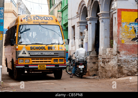 Indian school bus going through a small indian town. Andhra Pradesh, India Stock Photo