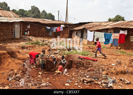 Children playing on a small section of spare land deep inside Kibera Slum, Nairobi, Kenya Stock Photo