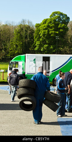 Man carrying tyres. Service area Armagh, Circuit of Ireland Rally 2011 Stock Photo