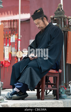 A taoist monk with a cellular, Taishan, China Stock Photo